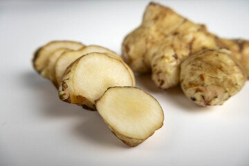 Jerusalem artichoke with slices pieces isolated on a white background.