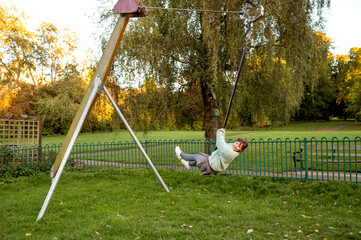 Young girl swinging on zip-line swing on playground.