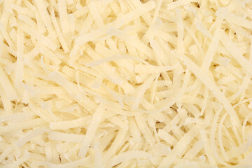 A detailed close-up shot shows a textured background completely filled with shredded yellow Parmesan cheese