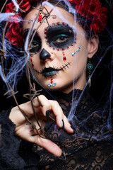 Female face Santa Muerte makeup covered with barbed wire and web. Halloween beauty portrait of woman.
