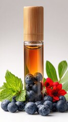 Essential oil bottle with blueberries, mint leaves, and red flowers