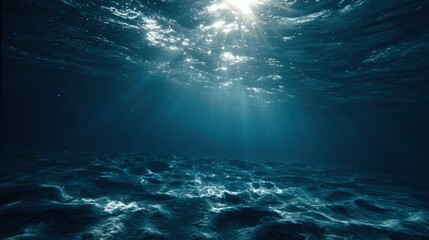 Underwater scene with sunlight penetrating the ocean surface, creating rays through deep blue water