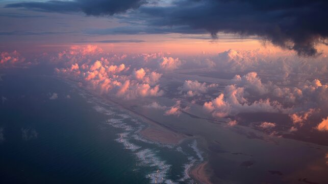 Aerial view of a coastline at sunset with dramatic clouds and ocean waves