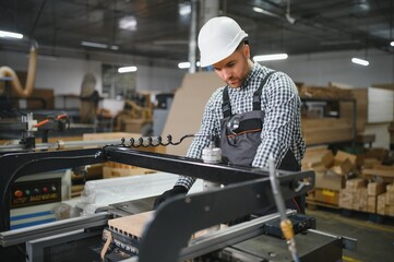 Carpenter operating cnc machine in furniture factory