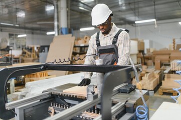Carpenter operating cnc machine in furniture factory