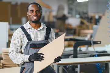 Furniture maker holding wooden component in factory