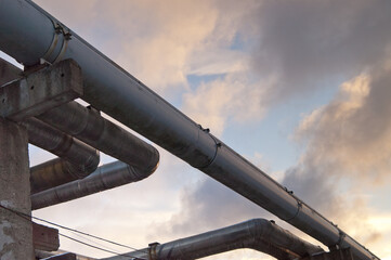 a pipeline on concrete piles against the backdrop of the evening sky