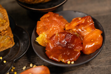 Candied kumquat on black plate, traditional Vietnamese sweet preserved fruit