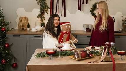 Friends celebrating holidays at home with gingerbread man and festive decorations