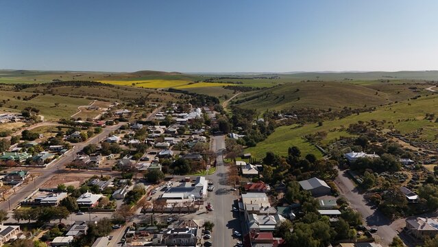 Burra, South Australia &ndash; Aerial Drone Image of Historic Pastoral Town, Country Houses, Estates, Streets, Canola Fields, and Wind Turbines in the Mid-North Agricultural Region