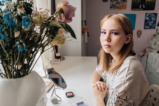 Young Woman with Purple Eye Makeup at Home Vanity