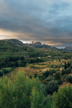 Scenic landscape with mountains under dramatic cloudscape at sunset