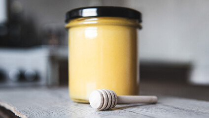 Natural Creamed Honey in Glass Jar with Wooden Dipper – Close-Up