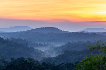 Beautiful nature landscape of sunrise or sunset over mist-covered mountains and valley with colorful sky and clouds