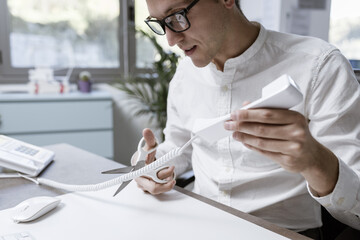Office worker cutting the telephone cord