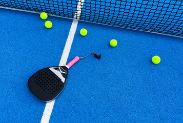 Naklejka na ściany i meble padel racket on a padel blue court 