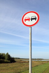 Overtaking is prohibited road sign in the evening against the sky
