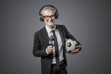 Sports journalist holding a soccer ball and a microphone