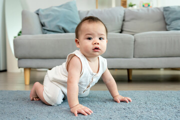 Asian young baby boy playing with toy alone in living room at home. 