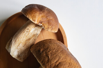 Freshly harvested porcini mushrooms on a wooden plate displayed for culinary use in autumn