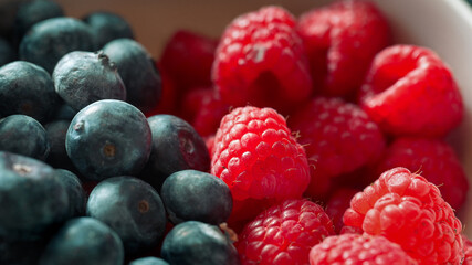 Macro shot of ripe blueberries and raspberries with natural light
