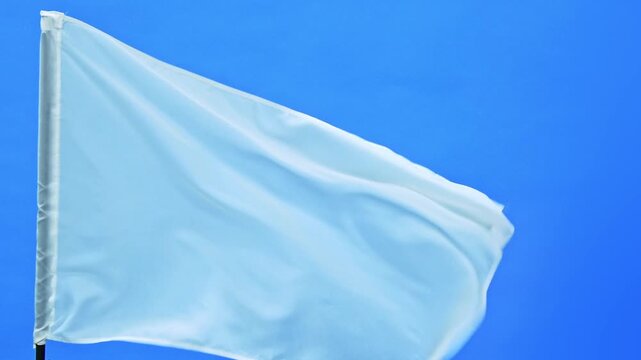 Slow motion video of white flag waving on blue background