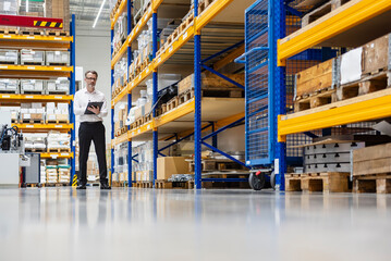 Businessman checking inventory in modern warehouse facility
