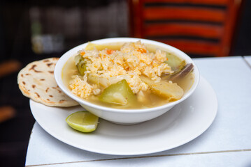 Authentic Bowl of Chicken Soup with Rice and Tortilla Dish