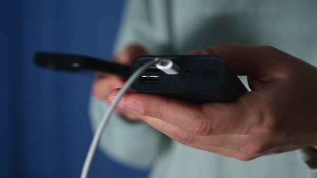 Mobile phone charging cables.
A person charges a dead smartphone using a portable charger.
Charger, mobile phone, charger, battery