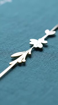 Close-up of an elegant golden metallic floral decorative element resting on a sophisticated textured teal surface showcasing delicate design and luxury craftsma