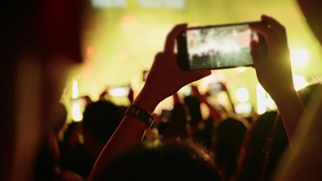 People using mobile phone camera at a concert, slow motion video