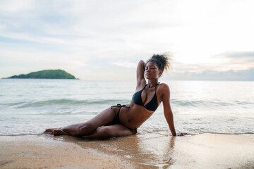 Beautiful African american woman in pink bikini on tropical beach. Portrait of dark skinned woman...