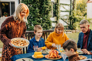 Family enjoying thanksgiving dinner outdoors in rural autumn setting