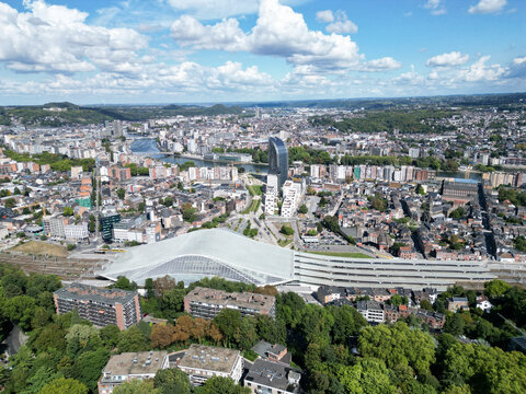 Aerial view of the modern Li&Atilde;&uml;ge-Guillemins railway station, the iconic Tour Paradis skyscraper, and the winding Meuse river cutting through the cityscape, Li&Atilde;&uml;ge, Wallonia, Belgium.