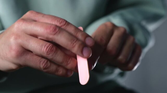 Nail file.
Using a nail file to smooth and polish sharp edges on the nail plate after trimming.