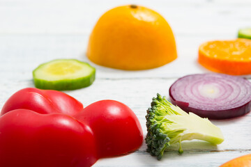 sliced fruit and vegetable circles on white wood table