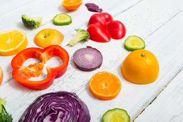 sliced fruit and vegetable circles on white wood table