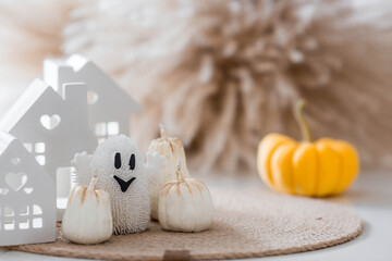 Autumn decor for Halloween. Cute ghost, white houses, and pumpkins. Banner, background for Halloween celebrations.