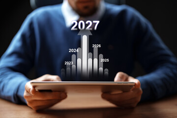 Businessman examining growth projections for future years on digital tablet in office setting