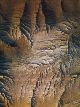 Aerial view of the eroded landscape reveals a canvas of contrasting light and shadow, sculpting a dramatic tableau of textures and tones, Goreme, Nevsehir, Turkiye.