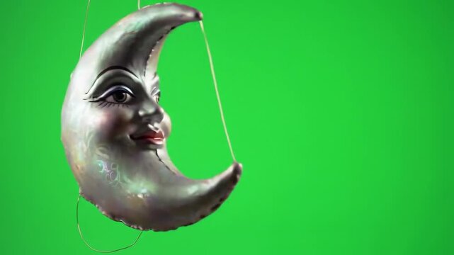 Crescent moon puppet on strings with green background