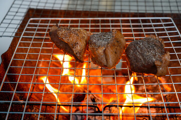 Grilled beef steak cooking on a charcoal fire. BBQ moments that bring people together.