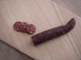 Traditional pork sausage sliced on a wooden cutting board. Smoked homemade delicacy from pig slaughter, typical for Easter and Central European cuisine.