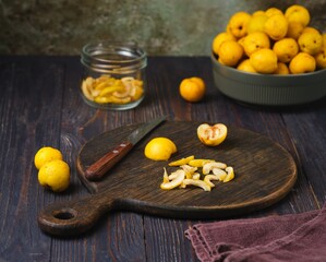 Japanese quince or chaenomeles fruits, peeled of seeds and sliced, on a brown board against a wooden background.