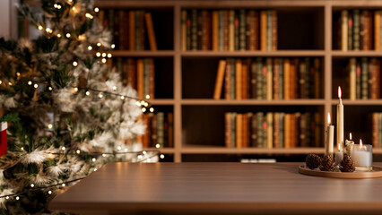 Candles and pinecones on wooden table across Christmas trees and bookshelf in living room or library © bongkarn