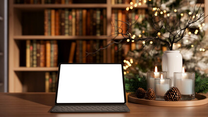 White screen tablet with lamp and candles on wooden table across bookshelf in living room or library © bongkarn