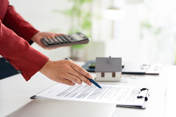 Mortgage home. real estate agent using calculator to find out the interest rate on a house mortgage.