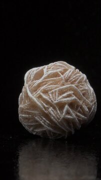 Desert Rose - Baryte (barium sulphate) c2cm across, rotating slowly against a black background. Vertical