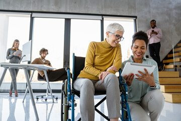 A diverse group of young professionals, including senior businesswomen entrepreneur in a wheelchair