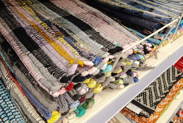 The texture of a colorful woven carpet with vertical stripes of various colors.